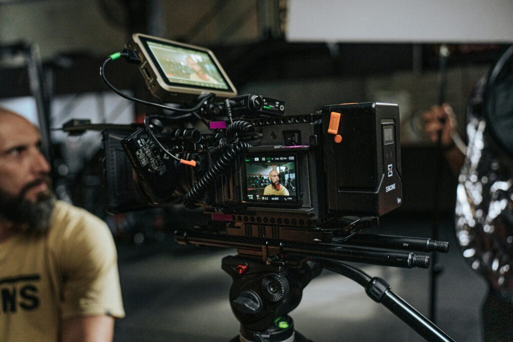 Close-up of a professional film camera setup with crew on a movie set, capturing behind-the-scenes action.